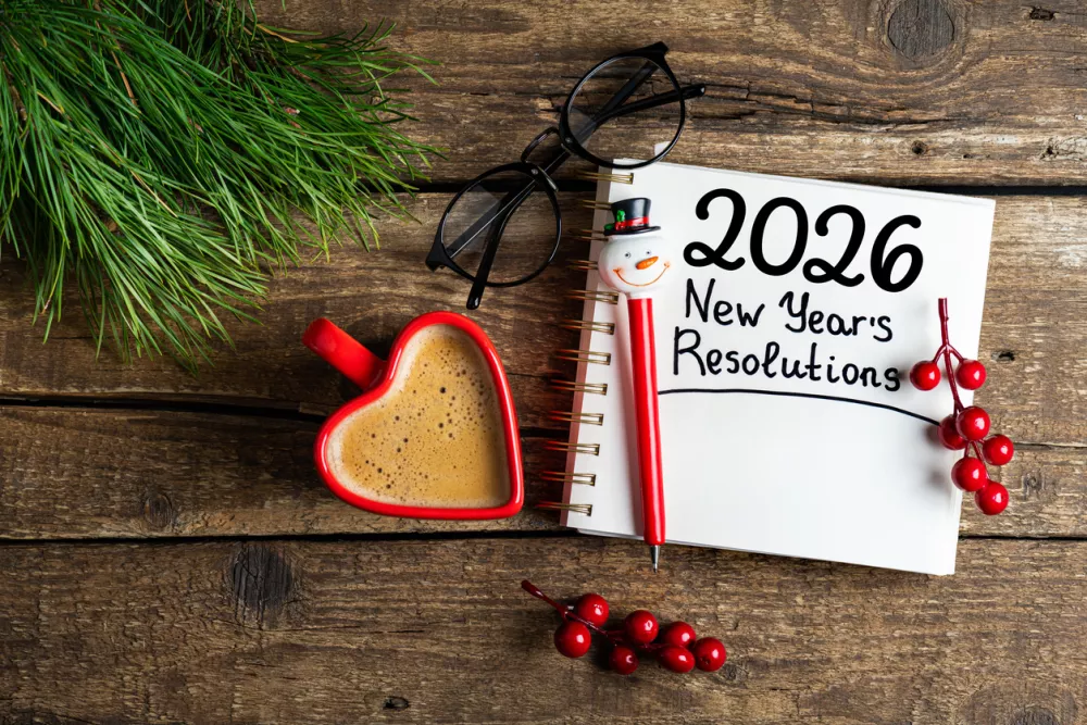 New year resolutions 2026 on desk. 2026 goals list with notebook, coffee cup on wooden table. Resolutions, plan, goals, action, checklist, idea concept. New Year 2026 resolutions, copy space