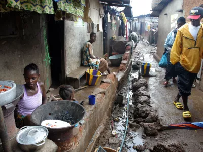 People wak through Moa Warf, a slum area in Freetown, Sierra Leone, June 3, 2004. REUTERS/Luc Gnago LG/CRB