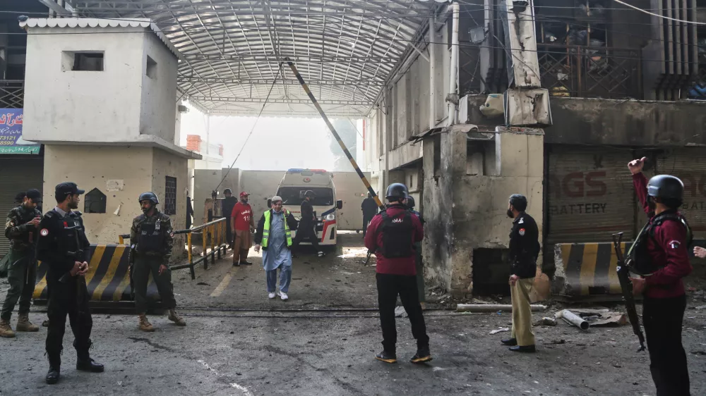Security officials examine the site of a suicide bombing attack at the main gate of headquarters of the Federal Constabulary (FC), in Peshawar, Pakistan, Monday, Nov. 24, 2025. (AP Photo/Muhammad Zubair)