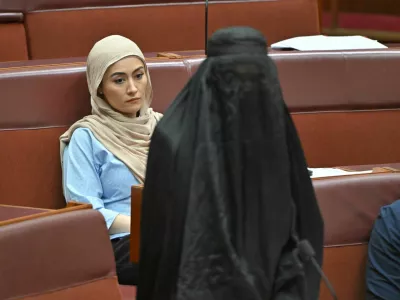 Independent senator Fatima Payman reacts as One Nation leader Pauline Hanson wears a burqa in the Senate chamber at Parliament House in Canberra, Australia, November 24, 2025. AAP/Mick Tsikas via REUTERS  ATTENTION EDITORS - THIS IMAGE WAS PROVIDED BY A THIRD PARTY. NO RESALES. NO ARCHIVE. AUSTRALIA OUT. NEW ZEALAND OUT. NO COMMERCIAL OR EDITORIAL SALES IN NEW ZEALAND. NO COMMERCIAL OR EDITORIAL SALES IN AUSTRALIA.