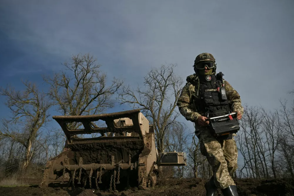 A sapper of the 808th 'Dnistrovska' Separate Support Brigade of the Ukrainian Armed Forces uses a GCS-200 remote-controlled demining machine during clearance of an agricultural field, amid Russia's attack on Ukraine, in Kherson region, Ukraine, November 22, 2025. REUTERS/Stringer