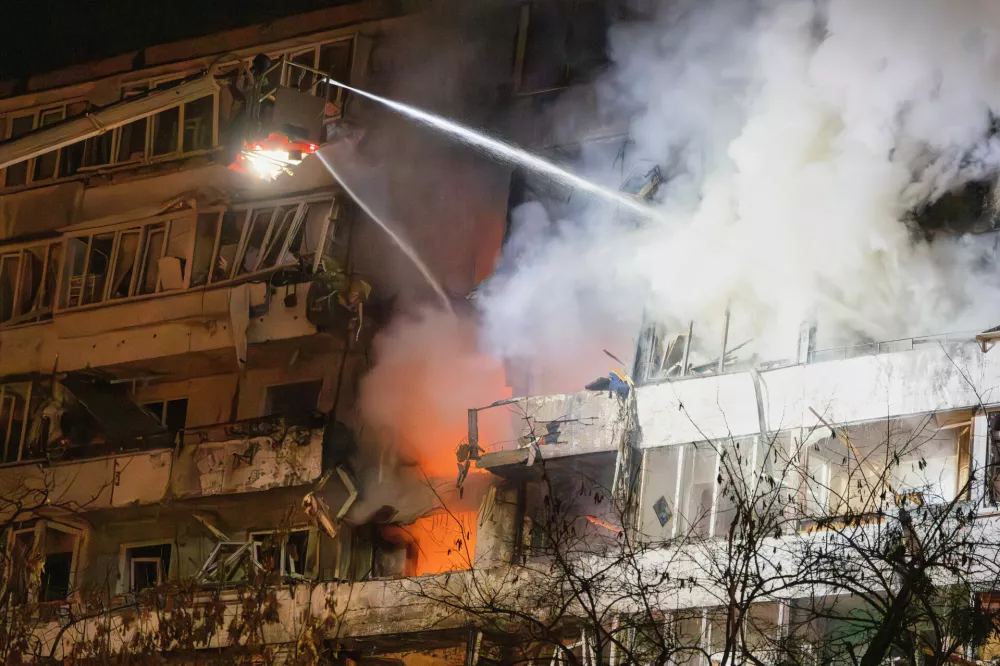 Firefighters put out the fire after a drone hit a multi-storey residential building during Russia's night drone attack in Kyiv, Ukraine, Tuesday, Nov. 25, 2025. (AP Photo/Efrem Lukatsky)