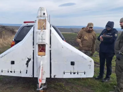 This image released by Moldova's Police on Tuesday, Nov. 25, 2025, police officers inspect a drone in the village of Cuhurestii de Jos, northern Moldova. (Moldova Police via AP)