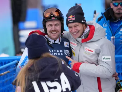 Nov 27, 2025; Copper, Colorado, USA; Aleksander Aamodt Kilde of Norway gets a hug from Marco Odermatt of Switzerland as Mikaela Shiffrin looks on during the men's Super G alpine skiing race at the Stifel Copper Cup at Copper Mountain. Mandatory Credit: Michael Madrid-Imagn Images