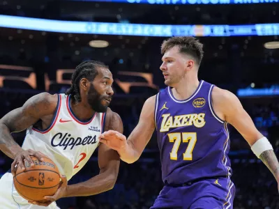 Los Angeles Lakers guard Luka Doncic (77) pressures Los Angeles Clippers forward Kawhi Leonard (2) during the second half of an NBA Cup basketball game Tuesday, Nov. 25, 2025, in Los Angeles. (AP Photo/Jae C. Hong)