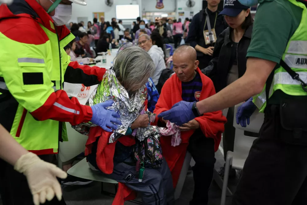 A woman receives medical attention at a temporary shelter, after a fire started across multiple buildings at Wang Fuk Court housing estate, in Tai Po, Hong Kong, China, November 26, 2025. REUTERS/Tyrone Siu