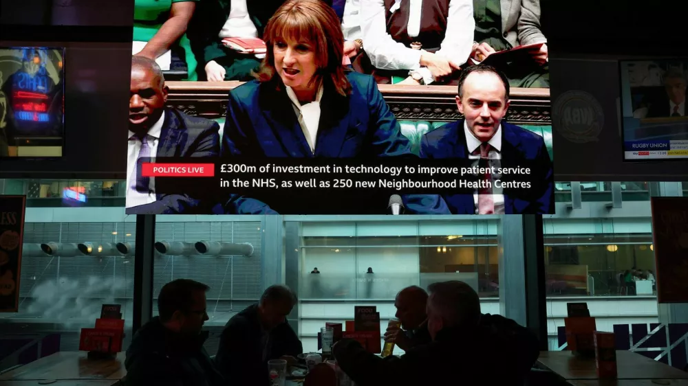 Britain's Chancellor of the Exchequer Rachel Reeves appears on a TV screen in a restaurant in the financial district of Canary Wharf as she presents the Autumn Budget Statement at the parliament, in London, Britain, November 26, 2025.  REUTERS/Kevin Coombs