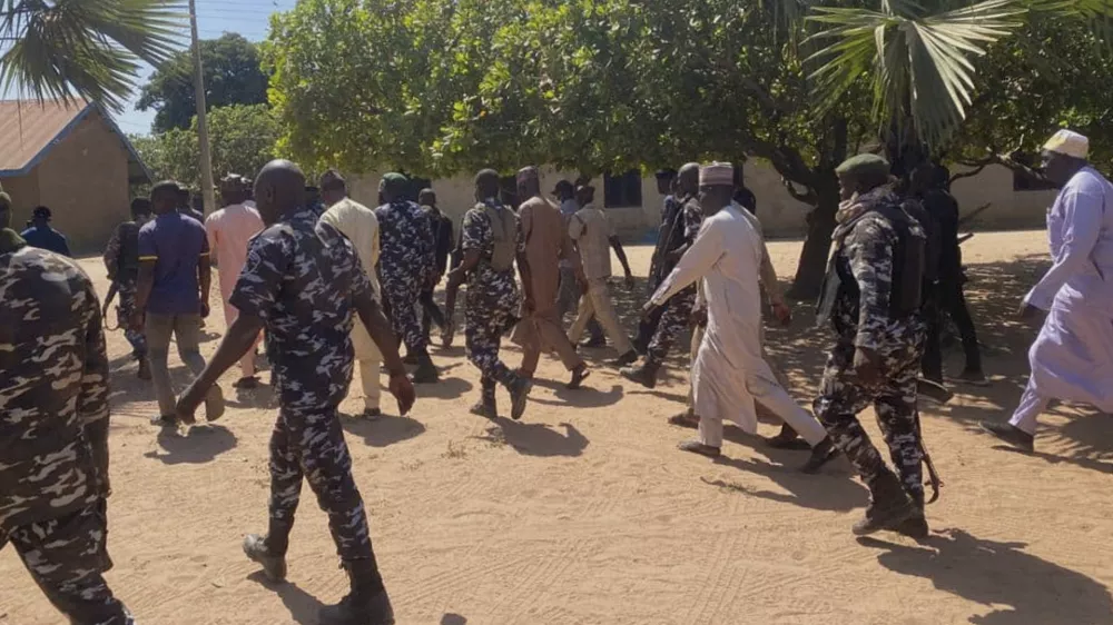 Police and government officials walk past St. Mary's Catholic Primary and Secondary School where gunmen on Friday abducted children and staff in Papiri community, Nigeria, Tuesday, Nov.25, 2025. (AP Photo/Yunusa Umar)