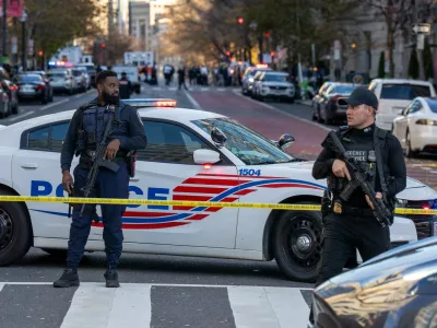 26 November 2025, US, WashingtonA D.C. Police officer and a Secret Service Uniformed Division officer block off a street with their rifles slung after two National Guardsmen were shot near the White House. PhotoJoey Sussman/ZUMA Press Wire/dpa