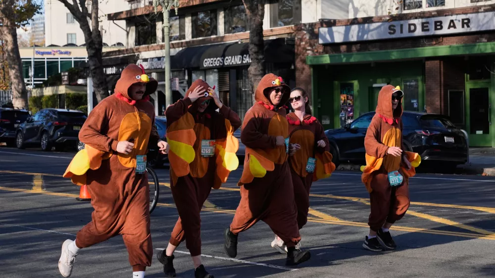 A group of people wearing turkey costumes run during the Oakland Turkey Trot in Oakland, Calif., Thursday, Nov. 27, 2025. (AP Photo/Godofredo A. V&aacute;squez)