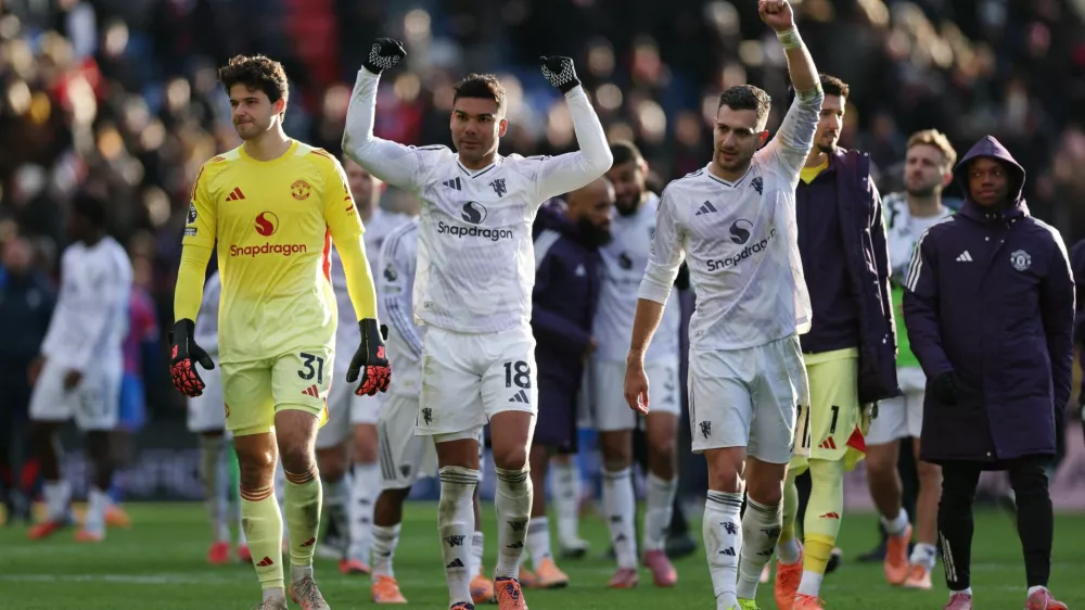 Soccer Football - Premier League - Crystal Palace v Manchester United - Selhurst Park, London, Britain - November 30, 2025 Manchester United's Senne Lammens, Casemiro and Diogo Dalot celebrate after the match Action Images via Reuters/John Sibley EDITORIAL USE ONLY. NO USE WITH UNAUTHORIZED AUDIO, VIDEO, DATA, FIXTURE LISTS, CLUB/LEAGUE LOGOS OR 'LIVE' SERVICES. ONLINE IN-MATCH USE LIMITED TO 120 IMAGES, NO VIDEO EMULATION. NO USE IN BETTING, GAMES OR SINGLE CLUB/LEAGUE/PLAYER PUBLICATIONS. PLEASE CONTACT YOUR ACCOUNT REPRESENTATIVE FOR FURTHER DETAILS..