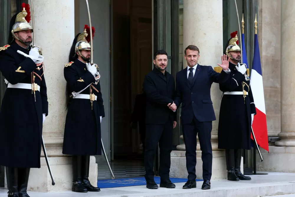 French President Emmanuel Macron shakes hands with Ukrainian President Volodymyr Zelenskiy as he arrives for a meeting at the Elysee Palace in Paris, France, December 1, 2025. REUTERS/Gonzalo Fuentes