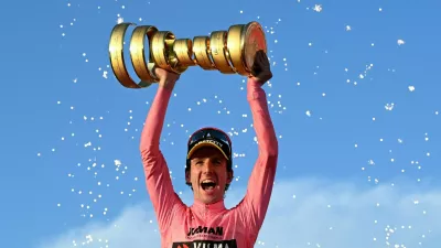 Cycling - Giro d'Italia - Stage 21 - Rome to Rome - Italy - June 1, 2025 Team Visma | Lease a Bike's Simon Yates celebrates with a trophy on the podium after winning the Giro d'Italia REUTERS/Jennifer Lorenzini  TPX IMAGES OF THE DAY