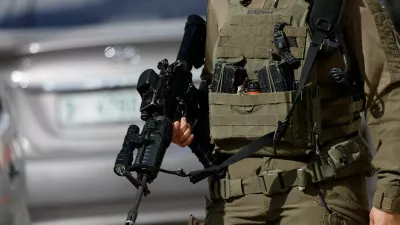 An Israeli soldier holds a gun, while taking part in an operation in Ramallah, in the Israeli-occupied West Bank, December 1, 2025. REUTERS/Mohamad Torokman