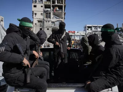 Hamas militants arrive at a site where they are searching for the remains of hostages in Jabalia, northern Gaza Strip, Monday, Dec. 1, 2025. (AP Photo/Jehad Alshrafi)