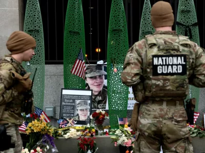 National Guard soldiers from Alabama look at a makeshift memorial honouring West Virginia National Guard soldier Sarah Beckstrom, who, with her wounded fellow soldier Andrew Wolfe, was shot outside a subway station near the White House in Washington, D.C., U.S., December 2, 2025. REUTERS/Evelyn Hockstein