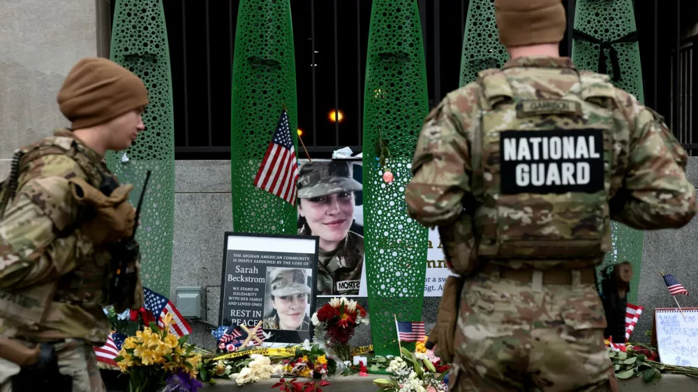 National Guard soldiers from Alabama look at a makeshift memorial honouring West Virginia National Guard soldier Sarah Beckstrom, who, with her wounded fellow soldier Andrew Wolfe, was shot outside a subway station near the White House in Washington, D.C., U.S., December 2, 2025. REUTERS/Evelyn Hockstein