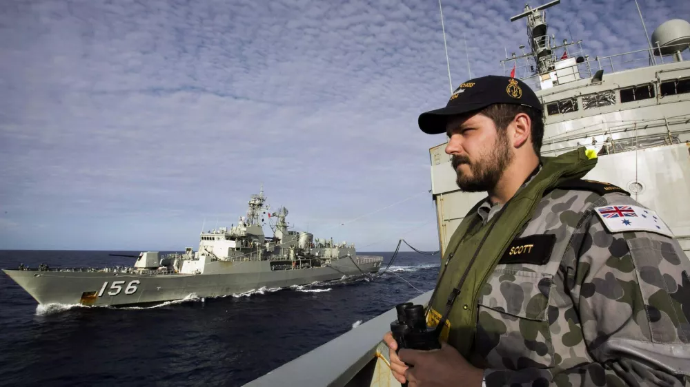 Able Seaman Maritime Logistics Steward Kirk Scott keeps watch aboard the Australian Navy ship HMAS Success as they conduct a replenishment at sea with HMAS Toowoomba while continuing to search for the missing Malaysian Airlines flight MH370, in this picture released by the Australian Defence Force April 11, 2014. Search and rescue officials in Australia are confident they know the approximate position of the black box recorders from missing Malaysia Airlines Flight MH370, Australian Prime Minister Tony Abbott said on Friday. At the same time, however, the head of the agency coordinating the search said that the latest "ping" signal, which was captured by a listening device buoy on Thursday, was not related to the plane. REUTERS/Australian Defence Force/Handout via Reuters (MID-SEA - Tags: MILITARY TRANSPORT DISASTER) ATTENTION EDITORS - THIS PICTURE WAS PROVIDED BY A THIRD PARTY. REUTERS IS UNABLE TO INDEPENDENTLY VERIFY THE AUTHENTICITY, CONTENT, LOCATION OR DATE OF THIS IMAGE. THIS PICTURE IS DISTRIBUTED EXACTLY AS RECEIVED BY REUTERS, AS A SERVICE TO CLIENTS. NO SALES. NO ARCHIVES. FOR EDITORIAL USE ONLY. NOT FOR SALE FOR MARKETING OR ADVERTISING CAMPAIGNS