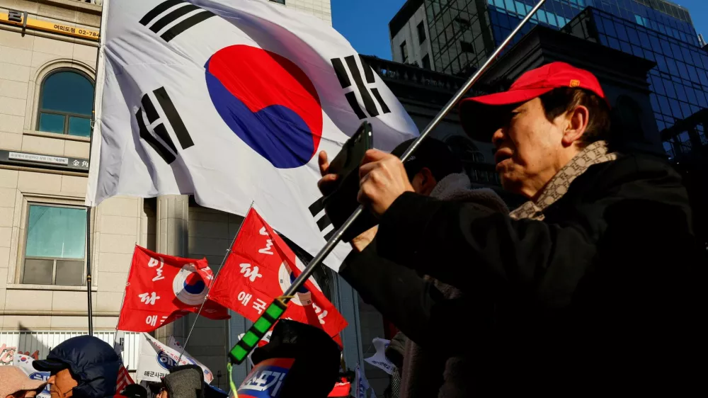 A far-right wing protester uses his phone during a rally to mark the first anniversary of former President Yoon Suk Yeol's December 3, 2024 martial law declaration, which they say was justified, near the headquarters of the People Power Party, in Seoul, South Korea, December 3, 2025. REUTERS/Kim Soo-hyeon