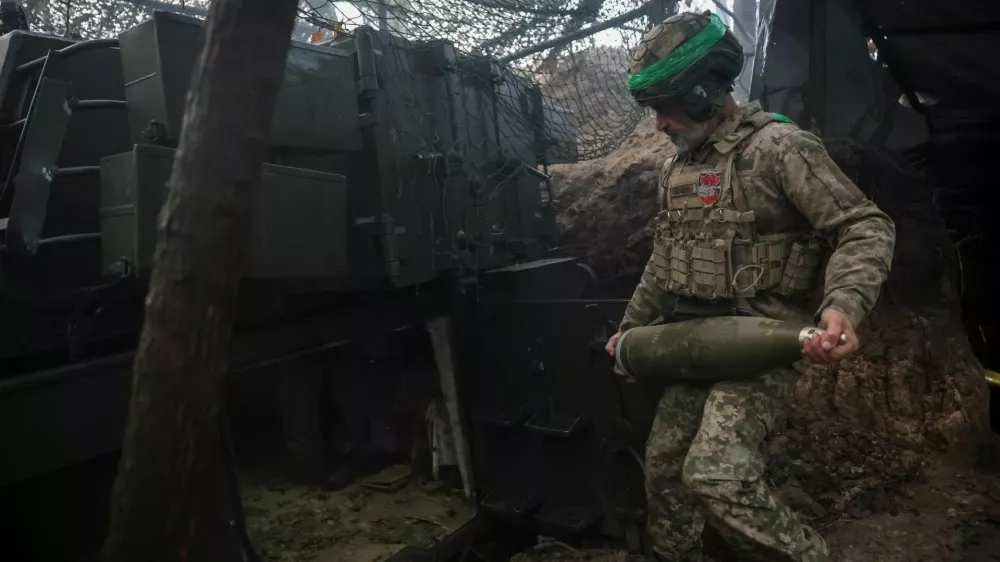 A serviceman of the 38th Separate Marine Brigade of the Ukrainian Armed Forces carries a shell for a M109A5 self-propelled howitzer as he prepares to fire towards Russian troops at a position in a front line, amid Russia's attack on Ukraine, near the frontline town of Pokrovsk in Donetsk region, Ukraine November 21, 2025. REUTERS/Anatolii Stepanov