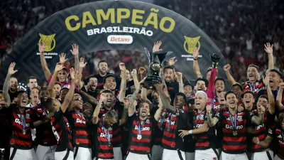Soccer Football - Brasileiro Championship - Flamengo v Ceara - Estadio Maracana, Rio de Janeiro, Brazil - December 3, 2025 Flamengo's Giorgian de Arrascaeta and Bruno Henrique lift the trophy as they celebrate with teammates after winning the Brasileiro Championship REUTERS/Ricardo Moraes