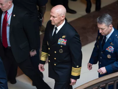 U.S. Navy Adm. Frank "Mitch" Bradley, center, commander of the U.S. Special Operations Command, and Gen. Dan Caine, chairman of the Joint Chiefs of Staff, right, are escorted to a classified briefing for top congressional lawmakers overseeing national security as they investigate how Defense Secretary Pete Hegseth handled a military strike on a suspected drug smuggling boat and its crew in the Caribbean near Venezuela Sept. 2, at the Capitol in Washington, Thursday, Dec. 4, 2025. (AP Photo/J. Scott Applewhite)