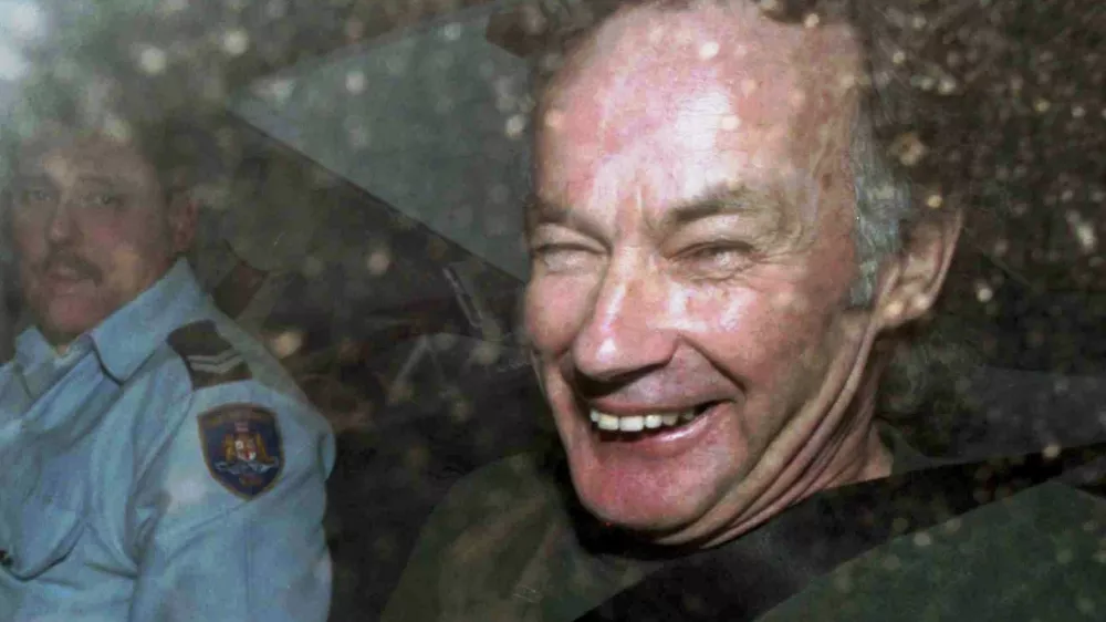 ﻿FILE - In this Nov. 4, 1997, file photo, Ivan Milat smiles in a police car after attending a court in Sydney, Australia. Milat, whose grisly serial killings of young backpackers horrified Australians in the early '90s, died in a Sydney prison on Sunday, Oct. 27, 2019, prison authorities said. He was 74. (AP Photo/Rick Rycroft, File)