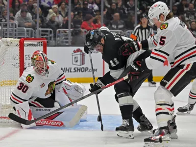 Dec 4, 2025; Los Angeles, California, USA; Chicago Blackhawks defenseman Connor Murphy (5) uses his stick to defend Los Angeles Kings center Anze Kopitar (11) as Chicago Blackhawks goaltender Spencer Knight (30) defends the net during the second period at Crypto.com Arena. Mandatory Credit: Jayne Kamin-Oncea-Imagn Images