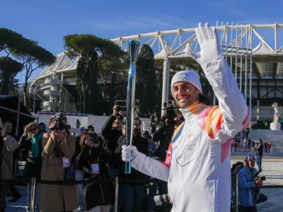 Italian swimmer Gregorio Paltrinieri carries the 2026 Milan Cortina Winter Olympics torch in Rome as it begins its journey through Italy, Saturday, Dec. 6, 2025, a journey that will conclude in Milan in February 2026. (AP Photo/Andrew Medichini)