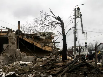 A worker of the DTEK energy company fixes power lines outside a house that was damaged during a night of Russian missile and drone strikes, amid Russia's attack on Ukraine, in Novi Petrivtsi, outside Kyiv, Ukraine, December 6, 2025. REUTERS/Thomas Peter