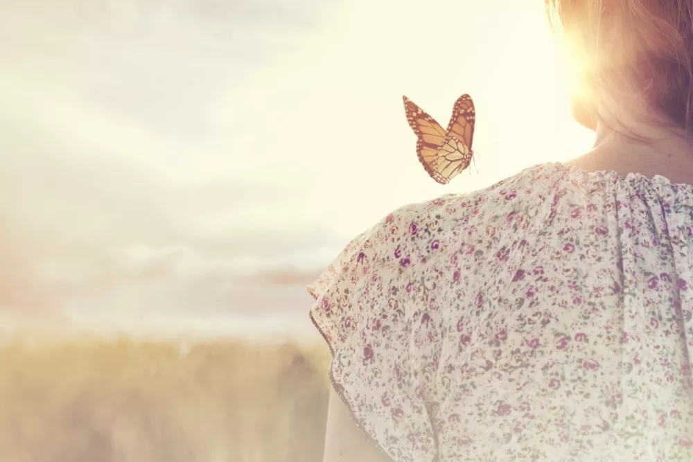 special moment of meeting between a butterfly and a girl in the middle of nature / Foto: Fcscafeine