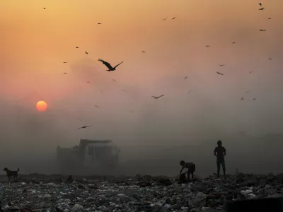 A thick blanket of smoke is seen against the setting sun as young ragpickers search for reusable material at a garbage dump in New Delhi, India, Friday, Oct. 17, 2014. India launched the Air Quality Index Friday to measure air quality across the nation that is home to some of the most polluted cities in the world. It will measure eight major pollutants that impact respiratory health in cities with populations exceeding 1 million in the next five years and then gradually the rest of the country, Environment Minister Prakash told reporters. The World Health Organization said earlier this year that the Indian capital had the worst air quality in the world, surpassing Beijing, a statement that New Delhi has vehemently disputed. (AP Photo/Altaf Qadri)
