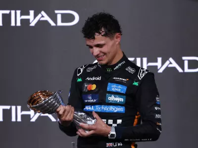 Formula One F1 - Abu Dhabi Grand Prix - Yas Marina Circuit, Abu Dhabi, United Arab Emirates - December 7, 2025 McLaren's Lando Norris celebrates on the podium with the trophy after becoming the 2025 Formula One World Champion REUTERS/Amr Alfiky