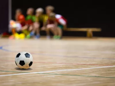 ﻿Football Futsal Ball and Youth Team. Indoor Soccer Sports Hall. Children Indoor Soccer Team. Sport Futsal background. Indoor Soccer Winter League for Kids