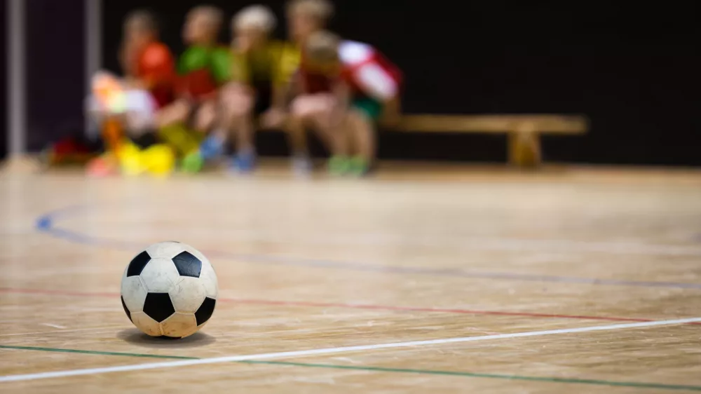 ﻿Football Futsal Ball and Youth Team. Indoor Soccer Sports Hall. Children Indoor Soccer Team. Sport Futsal background. Indoor Soccer Winter League for Kids