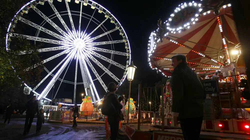 A giant ferris wheel is lit up on the opening night of 'Winter Wonderland', a christmas market and fun fair that is open to the public, in Hyde Park in London, Thursday, Nov. 17, 2011. (AP Photo/Kirsty Wigglesworth)