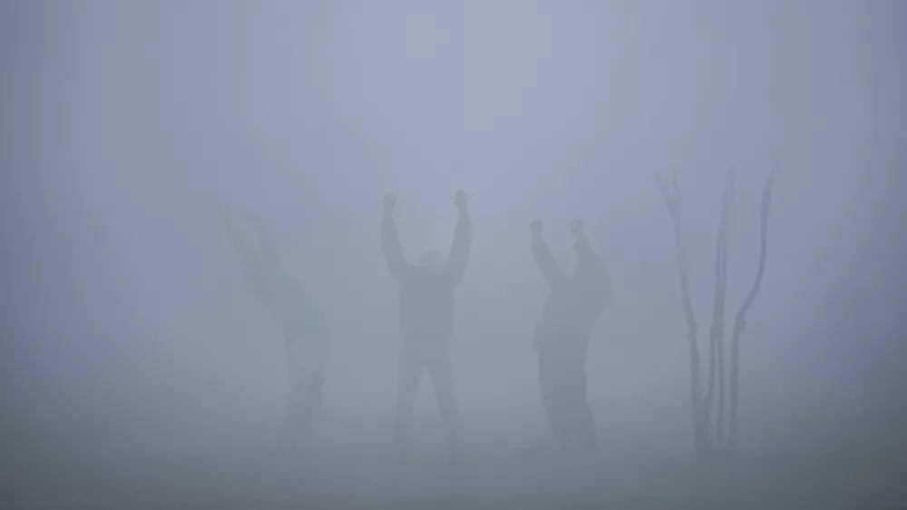 Three men participate in a laughter therapy session on a cold foggy morning in Srinagar, Indian controlled Kashmir, Monday, Nov. 20, 2023. (AP Photo/Mukhtar Khan) / Foto: Mukhtar Khan