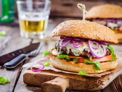 ﻿homemade burger with beef cutlet, apple, lettuce, onion and blue cheese on wooden table