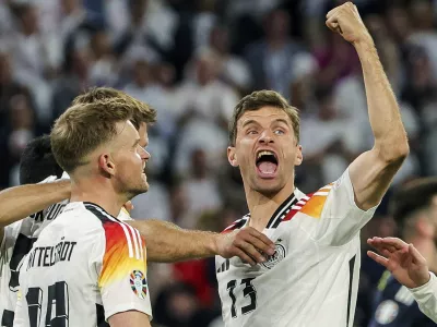 FILE - Germany's Thomas Mueller, right, celebrates during the Group A match between Germany and Scotland at the Euro 2024 soccer tournament in Munich, Germany, Friday, June 14, 2024. Germany forward Thomas Müller has announced his retirement from international soccer after a 14-year career that included the 2014 World Cup title. (Christian Charisius/dpa via AP, File)