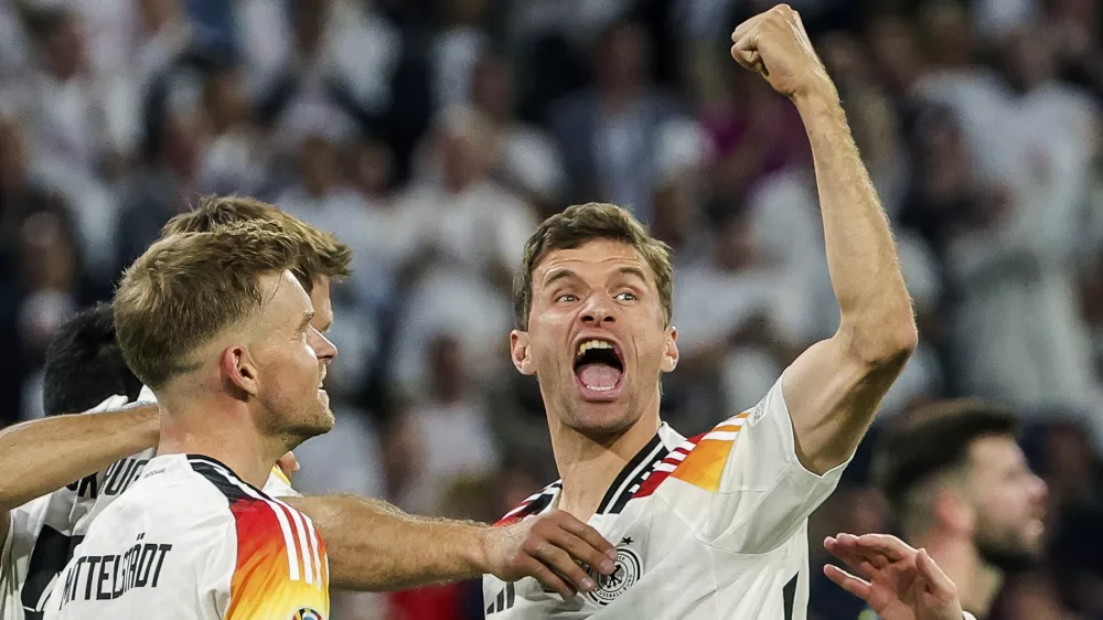 FILE - Germany's Thomas Mueller, right, celebrates during the Group A match between Germany and Scotland at the Euro 2024 soccer tournament in Munich, Germany, Friday, June 14, 2024. Germany forward Thomas Müller has announced his retirement from international soccer after a 14-year career that included the 2014 World Cup title. (Christian Charisius/dpa via AP, File)