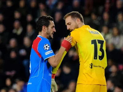 Atletico Madrid's Koke, left, giving the captain's armband to his teammate goalkeeper Jan Oblak during the Champions League opening phase soccer match between PSV and Atletico Madrid in Eindhoven, Netherlands, Tuesday, Dec. 9, 2025. (AP Photo/Patrick Post)