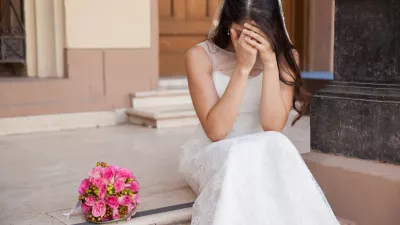 Hopeless bride crying outside a church after being stood up on her wedding day