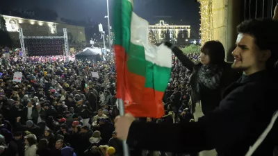 Students wave Bulgarian flag as as a swelling crowd of tens of thousands of Bulgarians filled Sofia's central square, demanding the government's resignation amid rising anger over corruption and contested economic policies, Sofia, Bulgaria, Wednesday, Dec. 10, 2025. (AP Photo/Valentina Petrova)