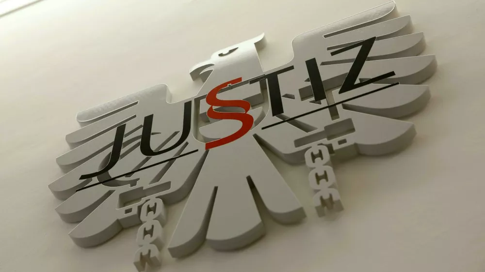 10 December 2025, Austria, Graz: The logo of justice in a courtroom at Graz East District Court. An Austrian court on Wednesday acquitted two surgeons working at a teaching hospital in Graz of a charge that they allowed a 12-year-old girl to participate in a neurosurgery operation. Photo: Erwin Scheriau/APA/dpa