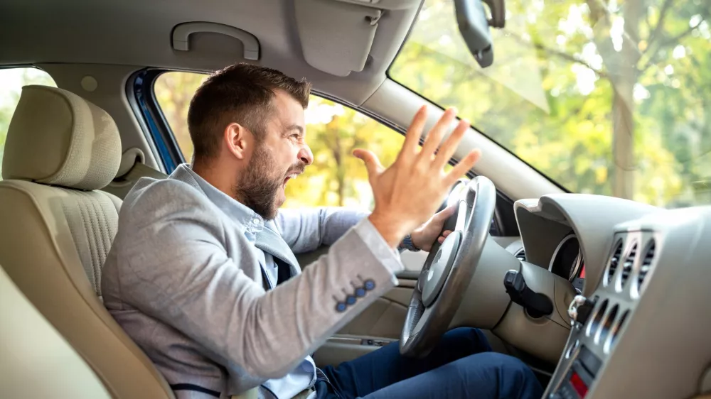 Really angry driver behind the steering wheel cannot keep his calmness / Foto: Didesign021