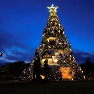 People stand near an illuminated Christmas tree during the holiday season in Batroun, northern Lebanon, December 10, 2025. REUTERS/Mohamed Azakir   TPX IMAGES OF THE DAY / Foto: Mohamed Azakir