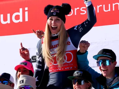 Alpine Skiing - FIS Alpine Ski World Cup - Women's Downhill - St. Moritz, Switzerland - December 13, 2025 Lindsey Vonn of the U.S. celebrates on the podium with her team after finishing second place in the Women's Downhill REUTERS/Denis Balibouse
