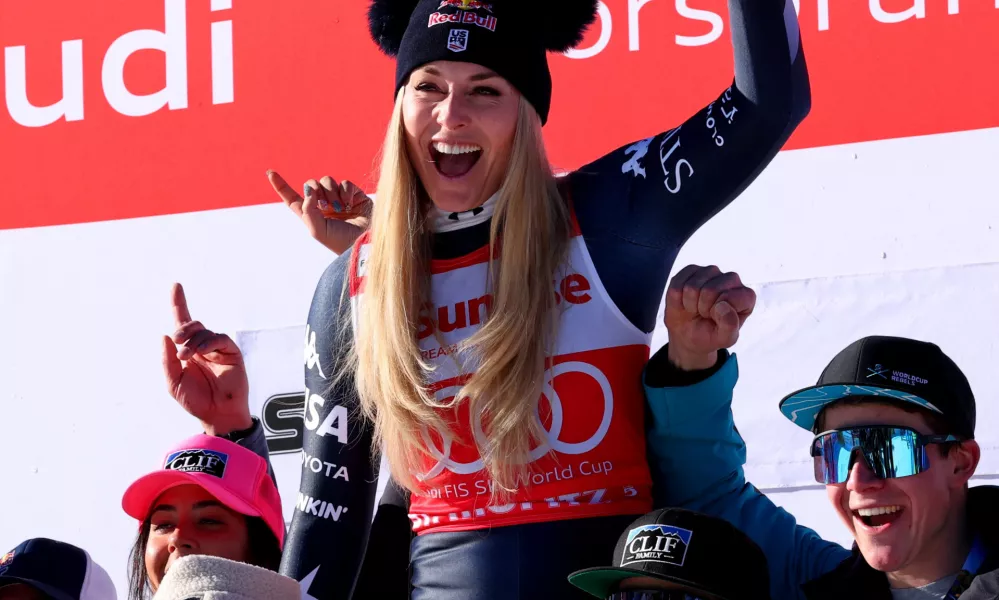 Alpine Skiing - FIS Alpine Ski World Cup - Women's Downhill - St. Moritz, Switzerland - December 13, 2025 Lindsey Vonn of the U.S. celebrates on the podium with her team after finishing second place in the Women's Downhill REUTERS/Denis Balibouse