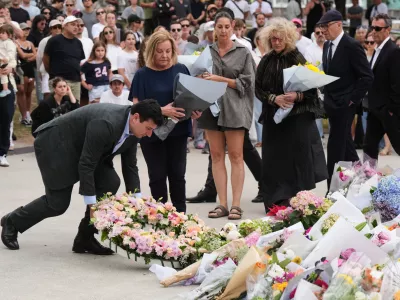 The current Mayor of Waverley Coucillor William Nemesh lays a wreath at a tribute for shooting victims outside the Bondi Pavilion at Sydney's Bondi Beach, Monday, Dec. 15, 2025, a day after a shooting. (AP Photo/Mark Baker)