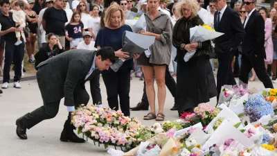 The current Mayor of Waverley Coucillor William Nemesh lays a wreath at a tribute for shooting victims outside the Bondi Pavilion at Sydney's Bondi Beach, Monday, Dec. 15, 2025, a day after a shooting. (AP Photo/Mark Baker)